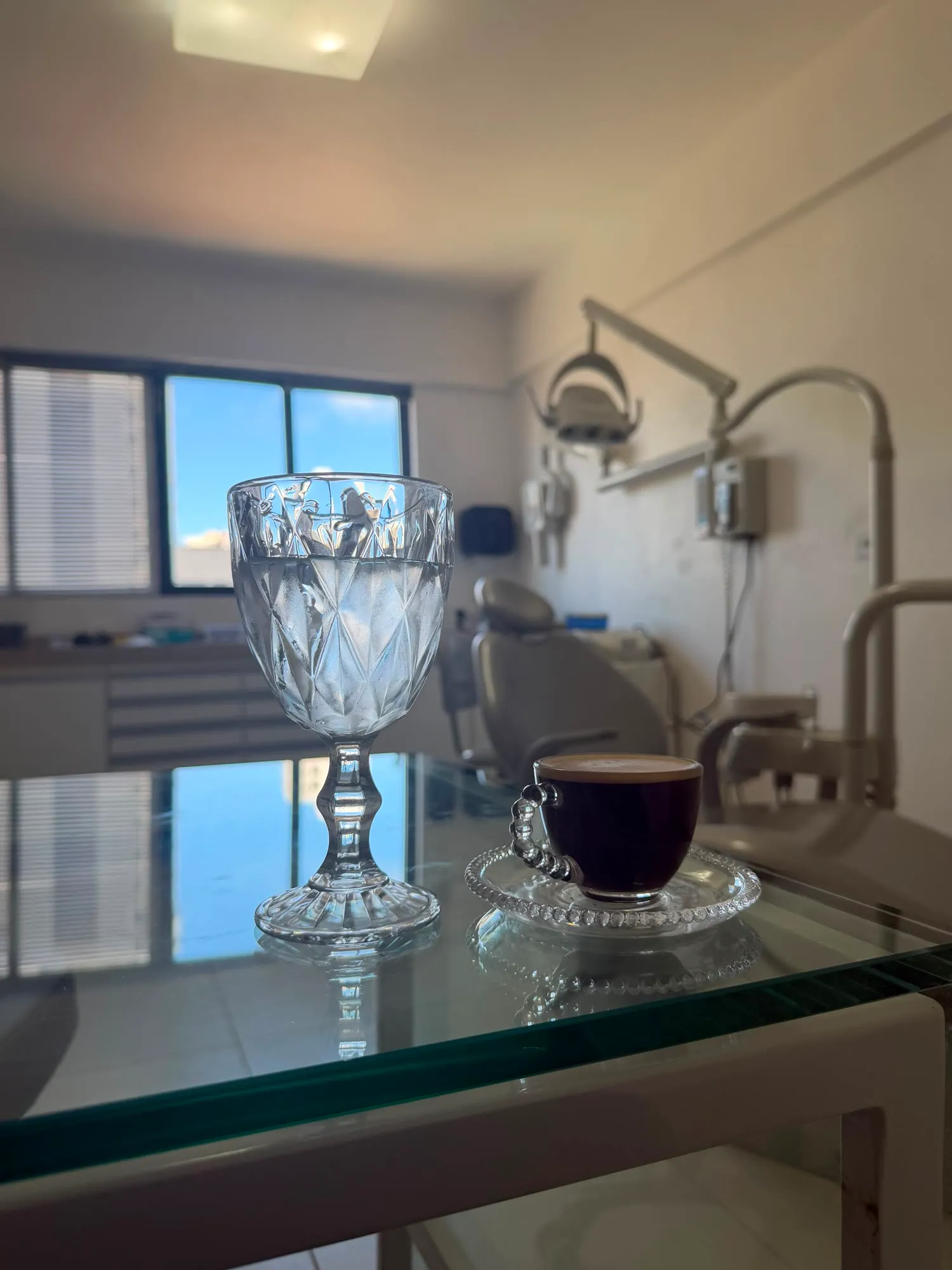 Café e taça de cristal sobre a mesa do consultório
